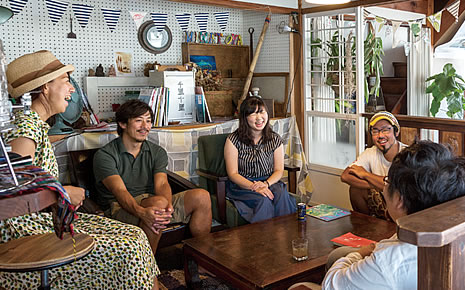 写真:ゲストハウス内でお客さんと談笑している大川さん夫妻。