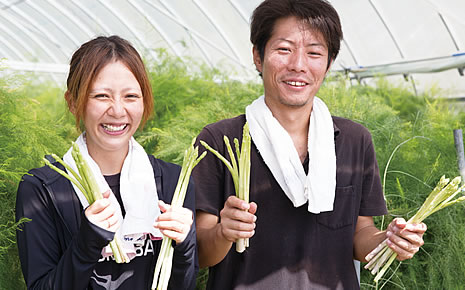 写真:アスパラガスを両手に握って笑顔の平田さん夫妻。